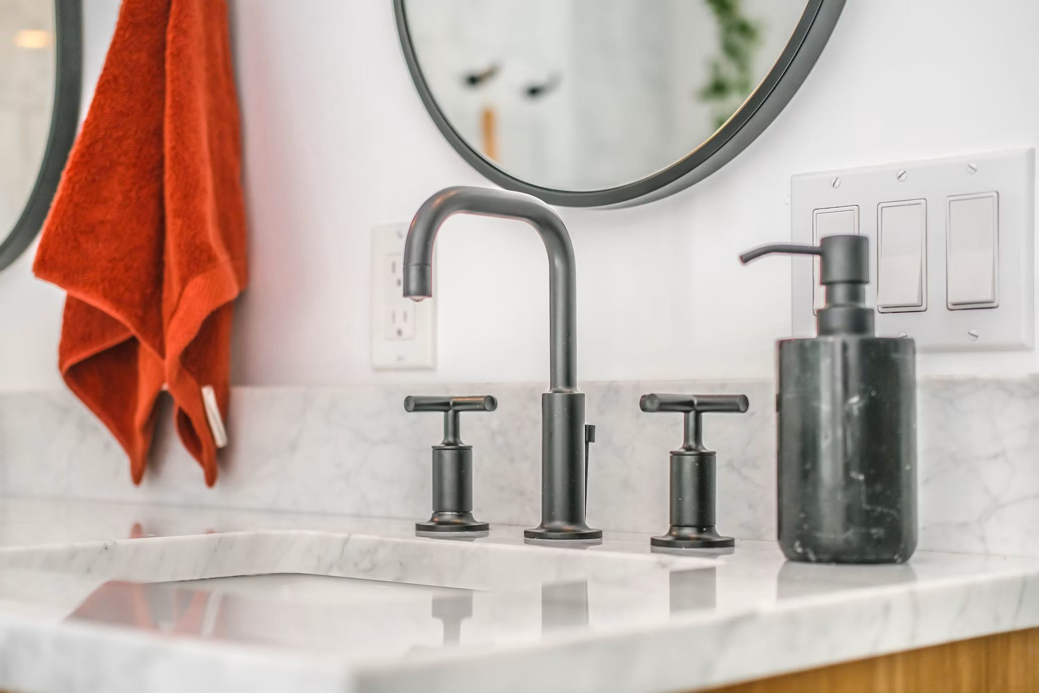 Widespread bathroom faucet and shutoff valves on a marble vanity
